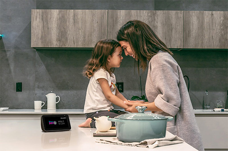 Mother and daughter sitting in a kitchen with an Amazon Echo Show 