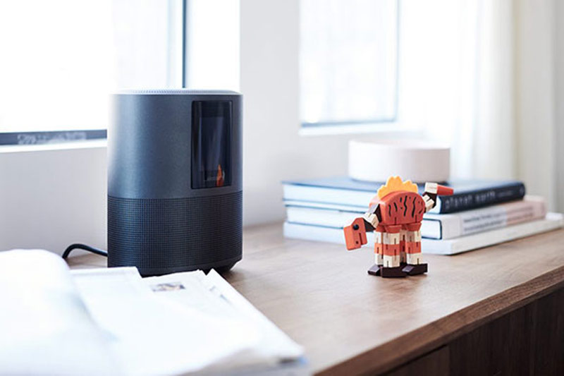 Bose device and small dinosaur toy on a shelf by the window