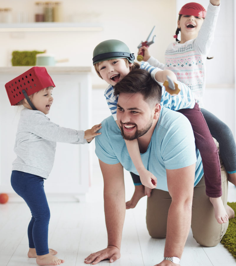 Dad with three kids playing in house