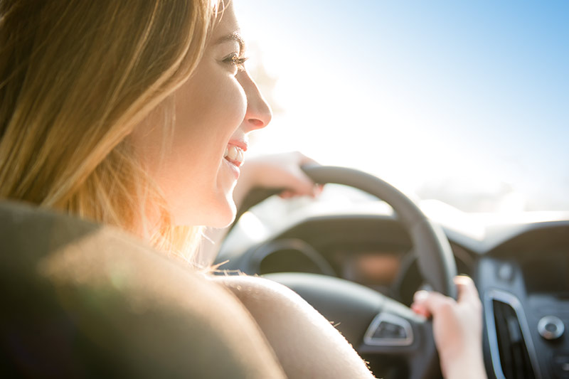 Woman driving holding steering wheel