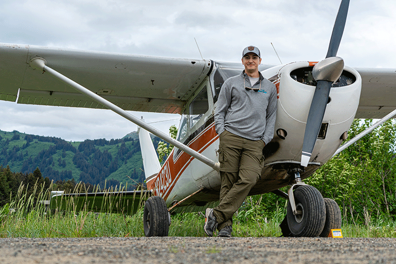 Pilot Josh Flowers standing next to a small plane