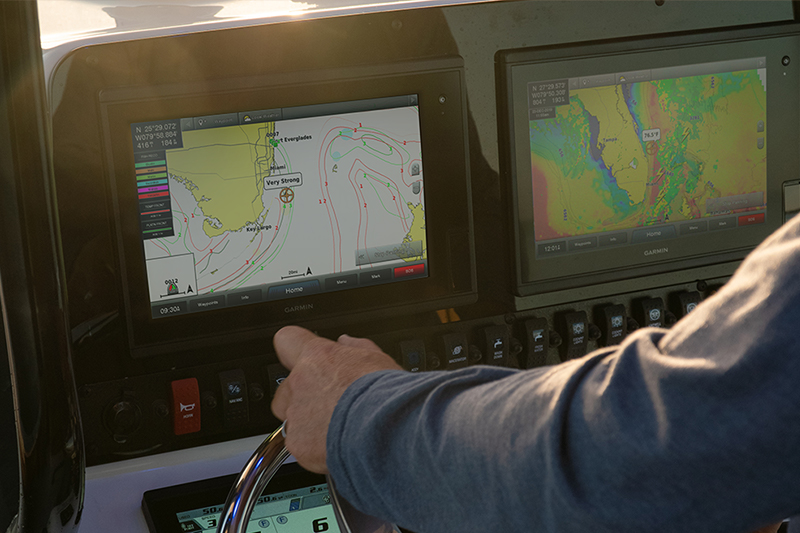 Man steering boat with Garmin navigation